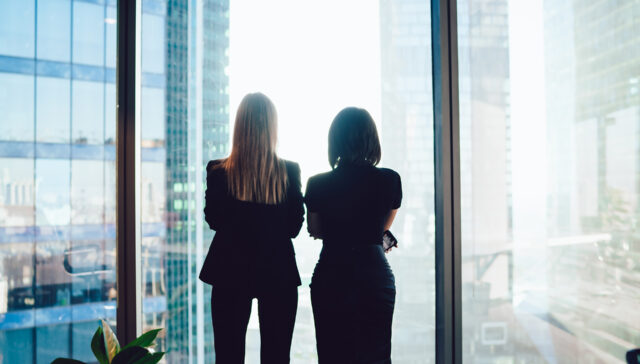Businesswomen standing near window in workplace